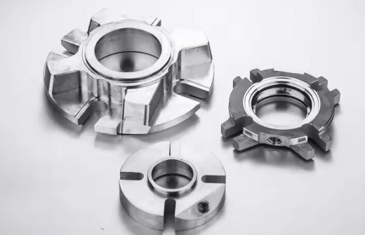 Three precision-machined metal coupling components with slots and central holes.